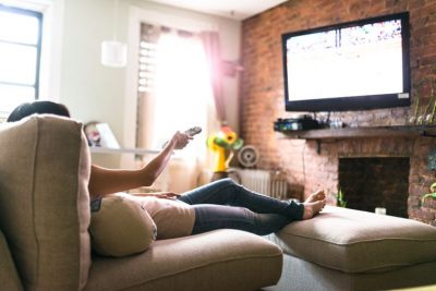 photo of person on couch watching television